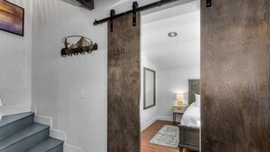 A staircase leading to a bedroom with a bed, a nightstand, and a lamp. - Bluebird Day - Lakewood Cottage in Bend with 2 beds, perfect for 4 guests. (Bend)