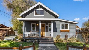 A two-story house with a front porch, a small attached garage, and a well-maintained lawn. - Bluebird Day - Lakewood Cottage in Bend with 2 beds, perfect for 4 guests. (Bend)