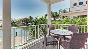 A balcony with wicker furniture and a view of a marina. - Family-Friendly Waterfront Paradise! (Holmes Beach)