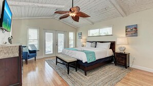 A bedroom with a bed, a desk, a chair, a ceiling fan, and a television. - Family-Friendly Waterfront Paradise! (Holmes Beach)