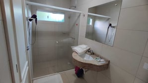 Une salle de bain avec une douche, un lavabo et un miroir.