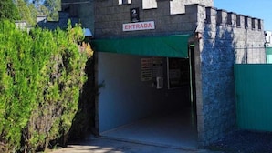 Un motel appelé « Paradies Motel II », avec une façade qui ressemble à un château, une enseigne à l’entrée et un auvent vert.