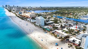 Un paysage urbain côtier avec une plage, des immeubles de grande hauteur et une marina.