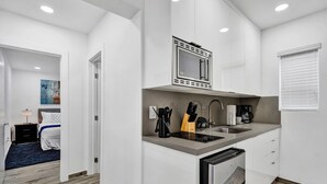 A modern kitchen with a built-in microwave, sink, and refrigerator. - Newly Renovated Apt-unit #1 Close to Beach (Hollywood)