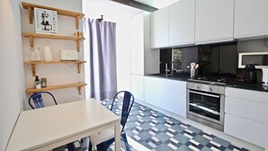 A modern kitchen with white cabinets, a Bosch coffee maker, and a patterned floor. - Bluebell Duplex Apartment, Anjos, Lisbon (Lisboa)