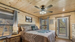 A wooden-paneled bedroom with a bed, nightstand, and dresser.