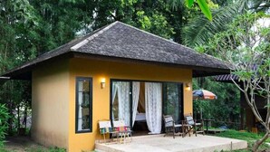 A small, single-story building with a sloped roof, large windows, and a patio area with outdoor seating. - Palette Luxe Elephant Camp Maerim (Mae Rim)