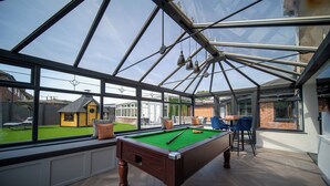 A pool table in a room with large windows and a view of a house. - 22-guest luxury stay with Pool & Bar (Lytham St Annes)