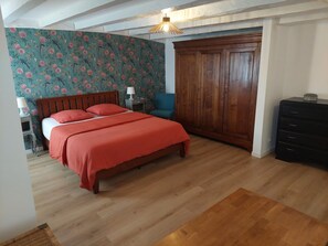Cozy bedroom with a comfortable bed, wooden wardrobe, and a bedside table.