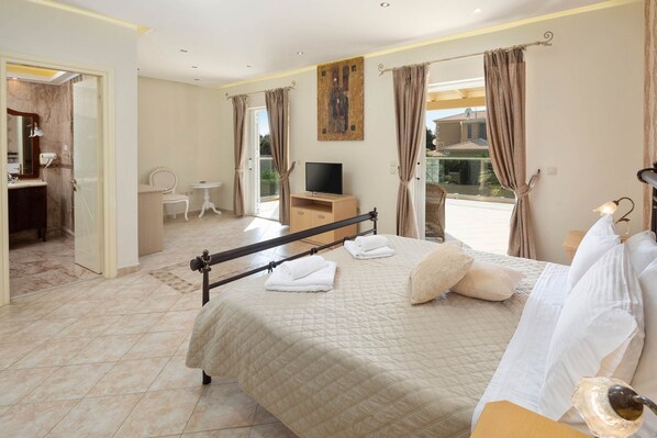 A hotel room with a bed, a TV, a desk, and a bathroom.