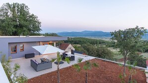 A modern house with a rooftop patio, outdoor seating, and a view of the countryside. - Luxury Villa with big private swimming pool surrounded by forest and wineyards (Imotski)