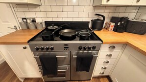 A kitchen with a gas stove, two ovens, and a wooden countertop. - Spacious Sheffield Lodge (Sheffield)