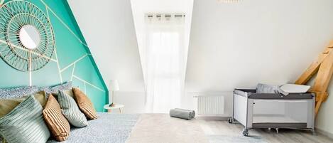 A modern bedroom with a bed, a radiator, a ceiling fan, and a window.