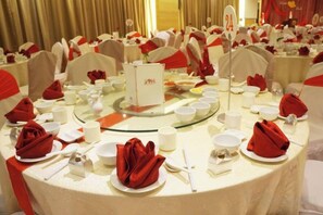 A banquet hall with round tables set for a formal event, complete with white tablecloths, red napkins, and floral centerpieces. - Sabah Oriental Hotel Kota Kinabalu (Kota Kinabalu)