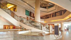 A multi-level interior with a central staircase, marble flooring, and a glass railing. - Sabah Oriental Hotel Kota Kinabalu (Kota Kinabalu)