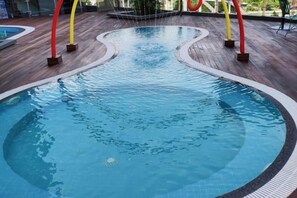 A swimming pool with a wooden deck surrounding it. - Sabah Oriental Hotel Kota Kinabalu (Kota Kinabalu)