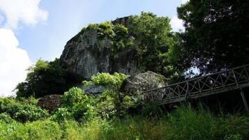 A natural rock formation with a metal bridge.