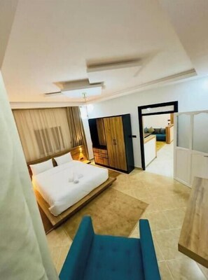 Una habitación de hotel moderna con una cama grande, un escritorio y un armario.