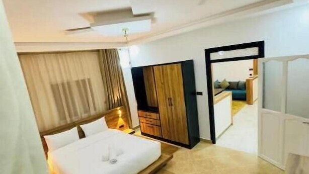 Una habitación de hotel moderna con una cama grande, un escritorio y un armario.