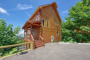 A log cabin with a porch, a staircase, and a view of the surrounding landscape. - 5-Star Mountain Views • Hot Tub • Blackstone • Game Room • Near Dollywood (Sevierville)
