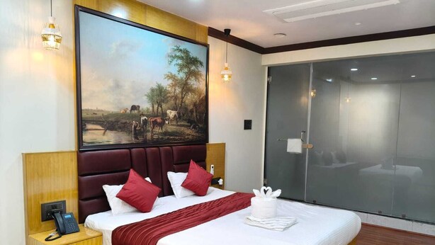 Une chambre d’hôtel avec un grand lit, un tableau, un téléphone et une porte coulissante.