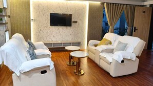 Un salon moderne avec deux canapés, une table basse et un téléviseur à écran plat fixé au mur.