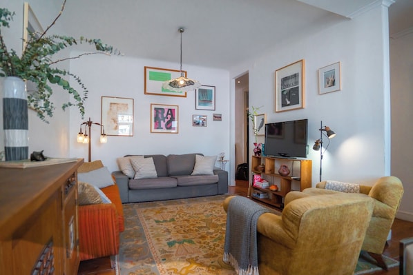 Relax in this inviting living room with a comfortable sofa, vibrant rug, and eclectic artwork.