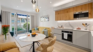Une cuisine moderne équipée d’un four encastré, d’un four à micro-ondes et d’un coin repas avec une table ronde et des chaises.