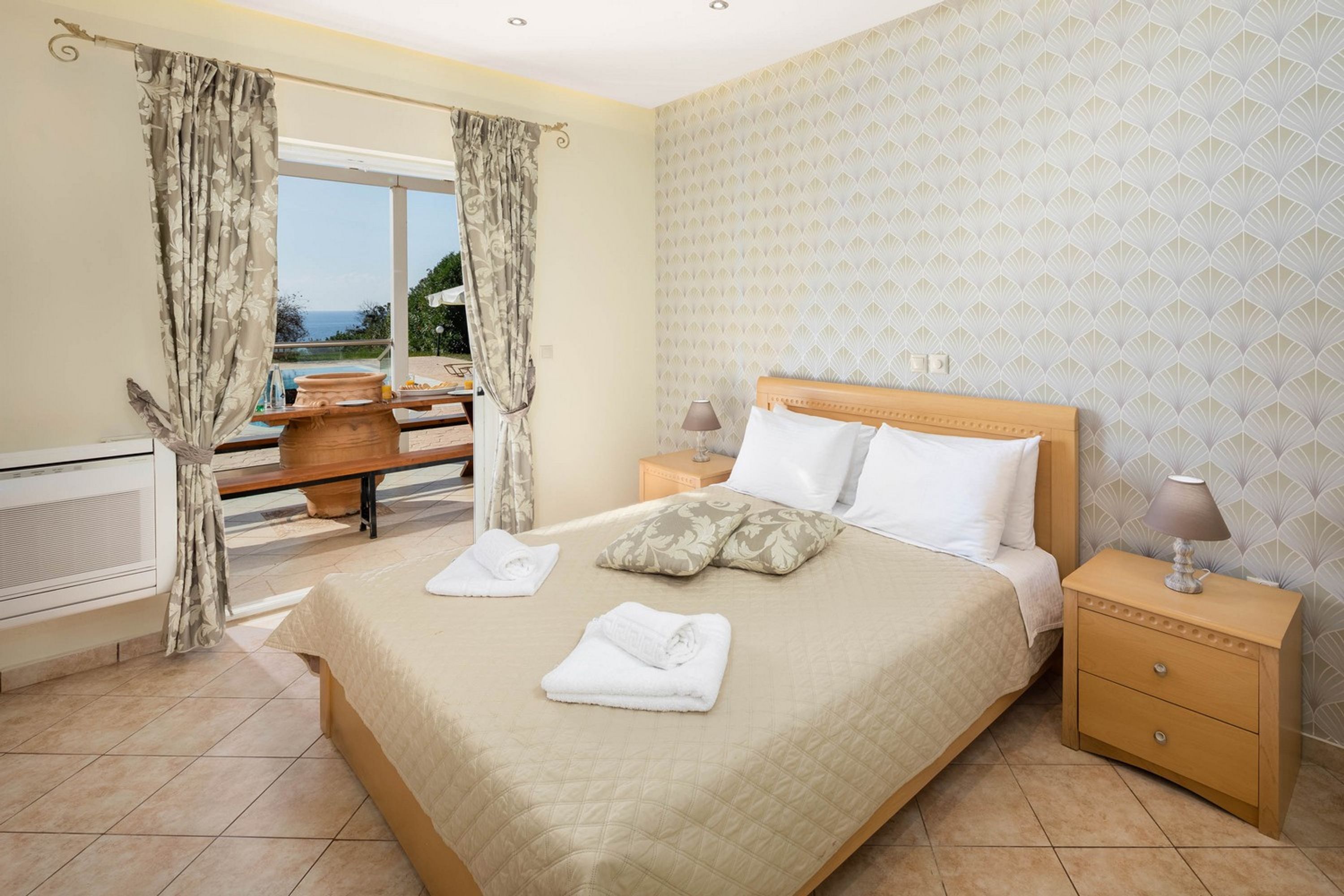 Une chambre d’hôtel avec un lit, une table de chevet et une vue sur l’extérieur.