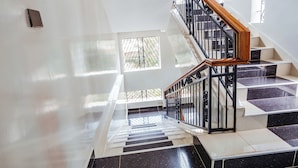 Un escalier moderne avec des carreaux noirs et blancs, une main courante en bois et une rampe en métal.