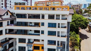 Un immeuble à plusieurs étages, doté de balcons, de grandes fenêtres et d’un toit plat.