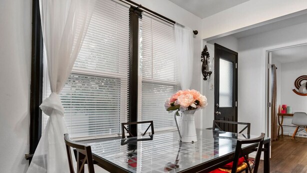 A dining area with a glass table, red cushioned chairs, and a vase with flowers. - Sleeps 12 , Safe area , Close to top attractions (St. Louis)