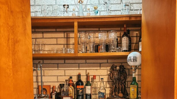 A bar area with shelves of bottles and glasses, a sink, and a decorative statue. - Rustic Texas Retreat: Ranch style Home Los Ebanitos Ranch  (San Isidro)