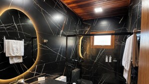 A modern bathroom with a black marble design, wooden ceiling, and a large mirror. - Pousada Maçã Araucária (São Joaquim)