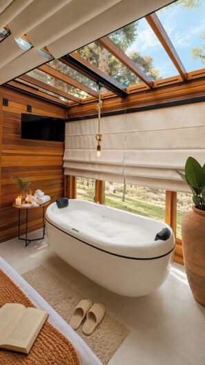 A modern bathroom with a freestanding bathtub, wooden walls, a large window, and a potted plant.
