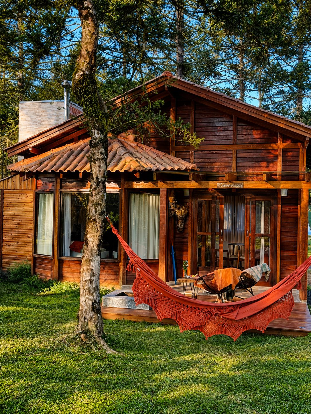 Una cabana de fusta amb un porxo, una cadira espanyola i una zona de menjador.