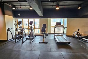 A gym with cardio machines, a treadmill, and a stationary bike. - Sunway Studio Homestay 1-min walk Sunway Pyramid Mall & Lagoon by Cloud Host (Subang Jaya)