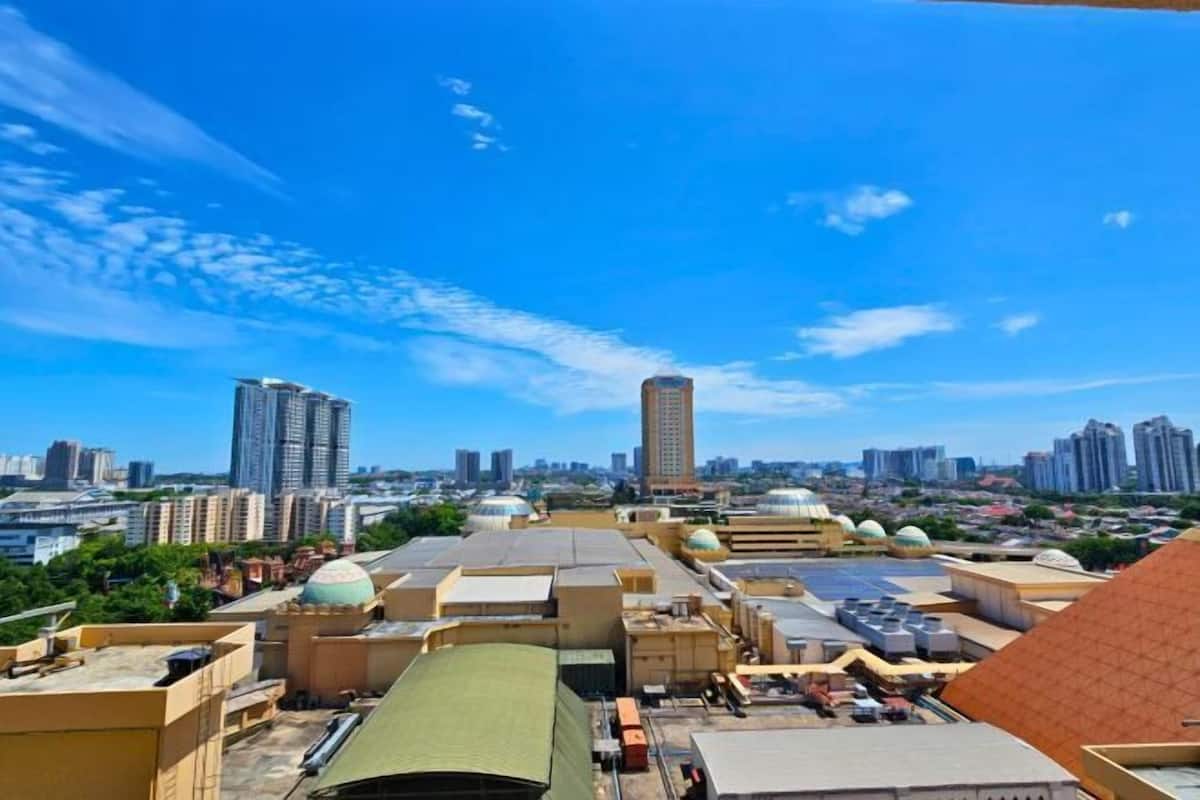 A cityscape with high-rise buildings and a variety of rooftops, including some with domed structures.