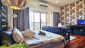 A modern hotel room with a bed, a sofa, a desk, and a balcony. - Sunway Studio Homestay 1-min walk Sunway Pyramid Mall & Lagoon by Cloud Host (Subang Jaya)