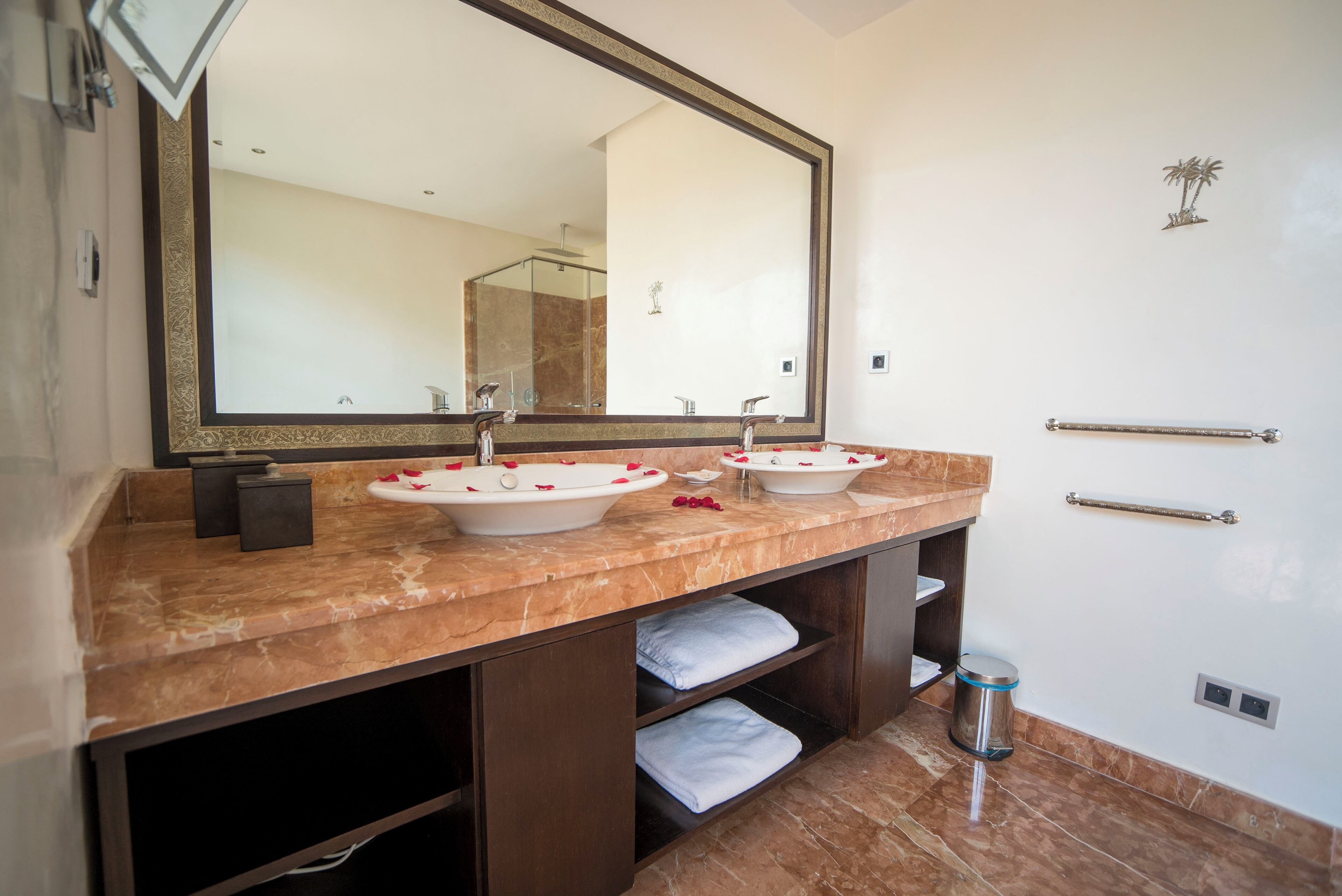 Une salle de bain avec deux lavabos, un grand miroir et un porte-serviettes.