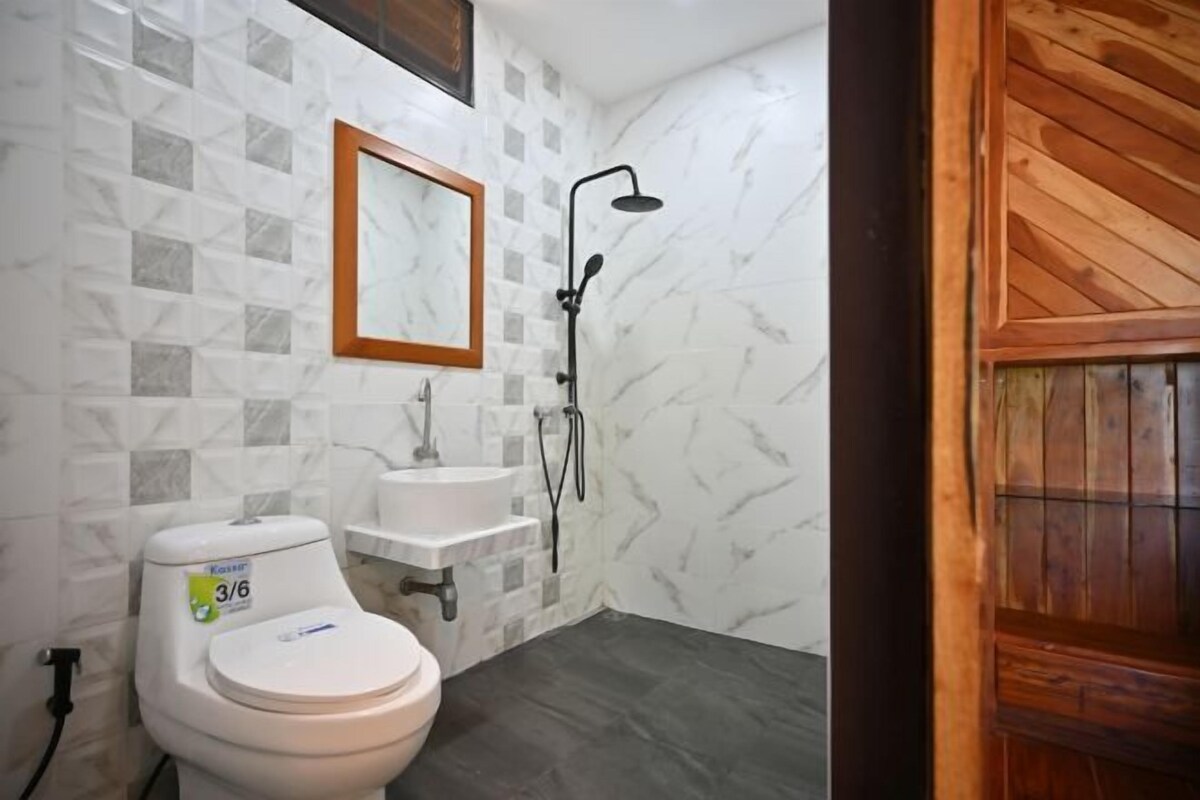 Un baño con inodoro, lavamanos y ducha.