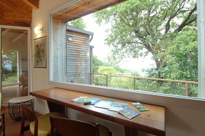 A wooden desk with books and a chair in a room with a large window overlooking a garden. - Casa Delle Eriche, Colli Euganei, Pool, Wifi (Teolo)