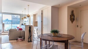A modern dining area with a round wooden table, clear chairs, and a potted plant. - AN ICONIC SPACE  IN AN ICONIC LOCATION  - AVENUE RAPP – NEXT TO EIFFEL   (Paris)