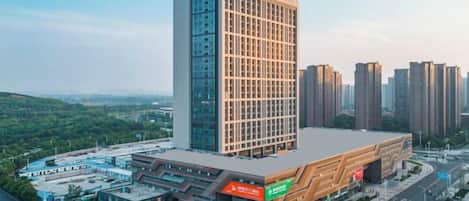 A modern hotel with a prominent central building and a flat-roofed structure with signage.