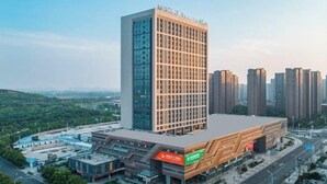Un edificio moderno con una facciata vetrata importante e un design architettonico originale.