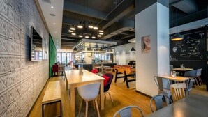 Un ristorante moderno con tavoli e sedie in legno, un muro di mattoni e una lavagna con una mappa.