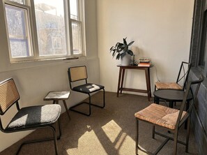 A room with four chairs, a small table, and a potted plant. - Flexhome Wicker Park • Stylish 2BR • Sleeps 6 (Chicago)