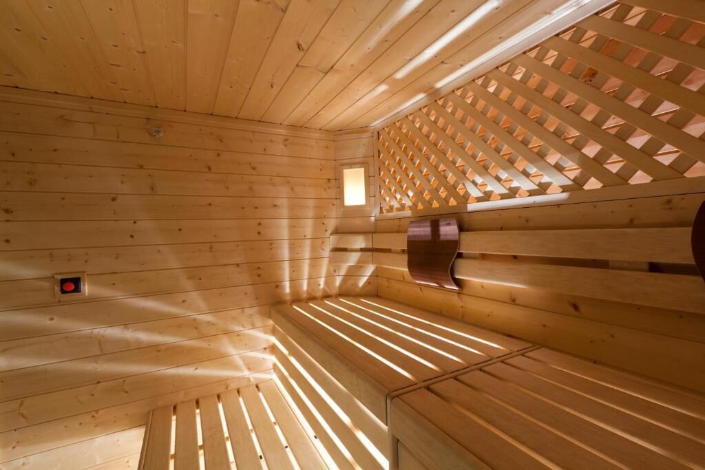Un sauna en bois, doté de bancs et d’une fenêtre à croisillons.