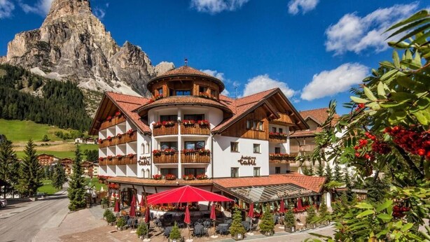 Ein Hotel mit Innenhof, Sitzgelegenheiten im Freien und Bergblick.