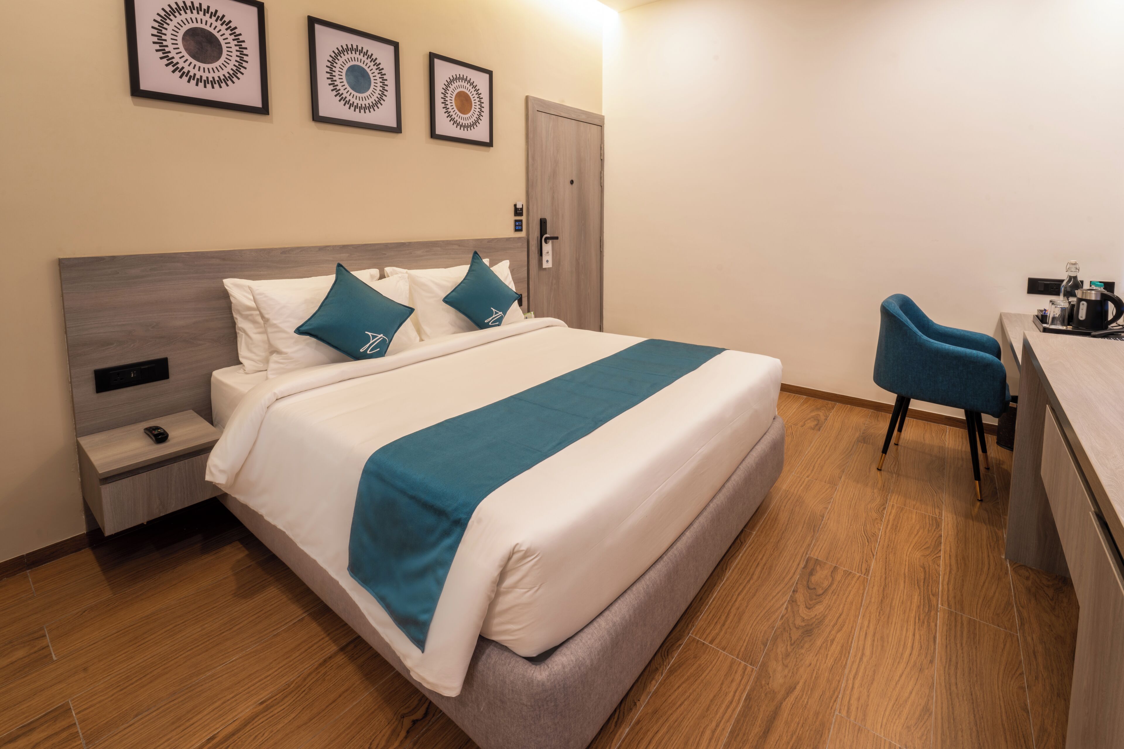 Una habitación de hotel con una cama, un escritorio, una silla y una puerta.